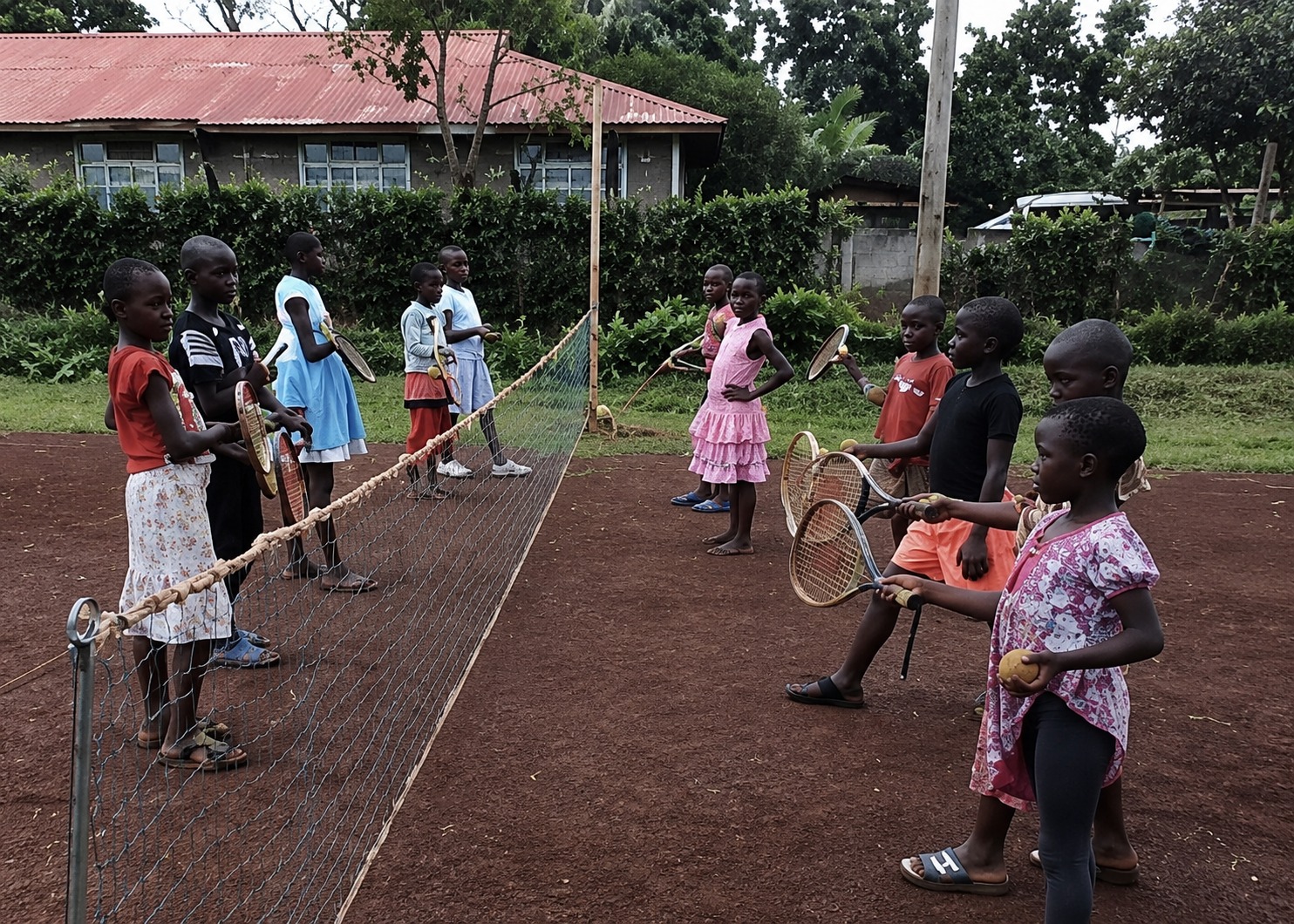 Lezione di tennis per bambini su campo in terra